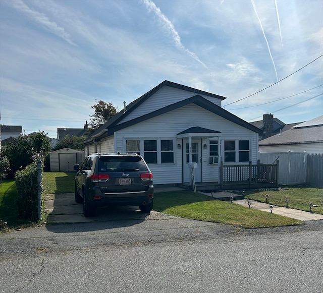 view of front of property with a storage unit and a front lawn