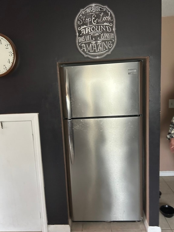 details with light tile patterned floors and stainless steel refrigerator