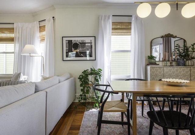dining area with dark wood-style flooring, ornamental molding, and baseboards