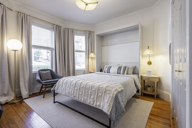 bedroom with crown molding and wood finished floors
