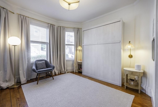 sitting room with ornamental molding and wood finished floors