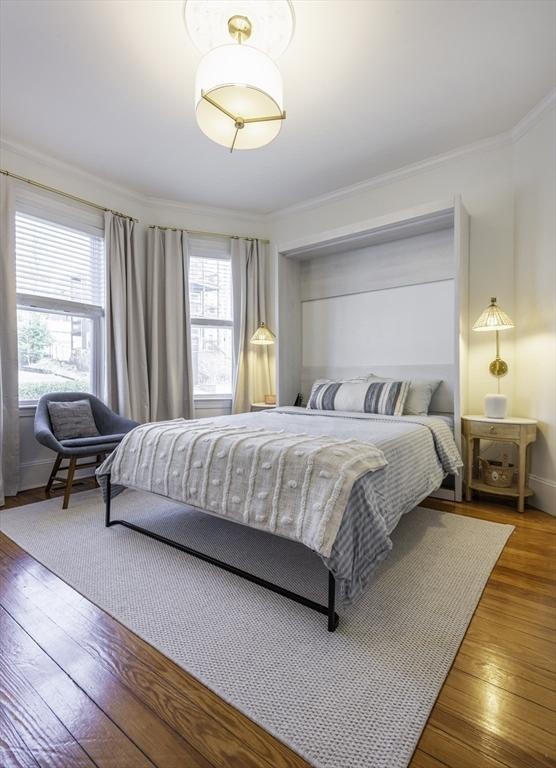 bedroom with wood-type flooring and crown molding