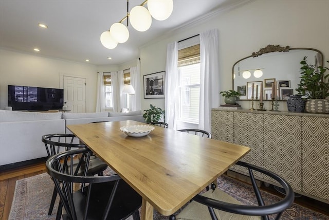 dining area with crown molding, healthy amount of natural light, dark wood finished floors, and recessed lighting