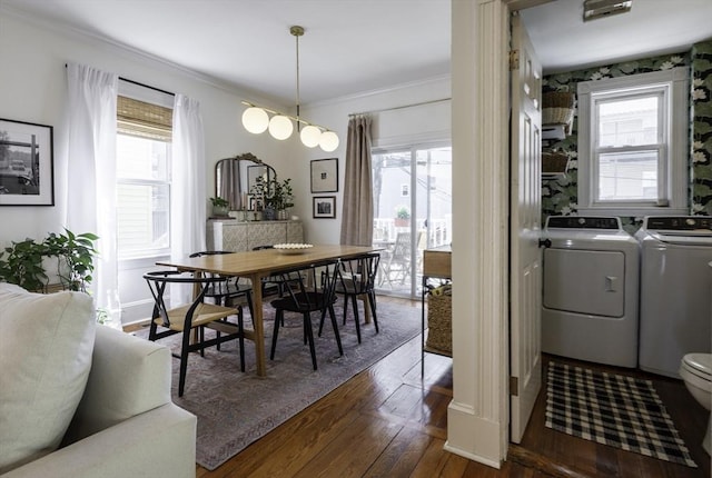 dining room with washer and clothes dryer, ornamental molding, wood finished floors, and healthy amount of natural light
