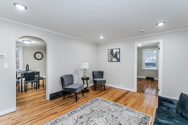 living area featuring crown molding and light wood-type flooring