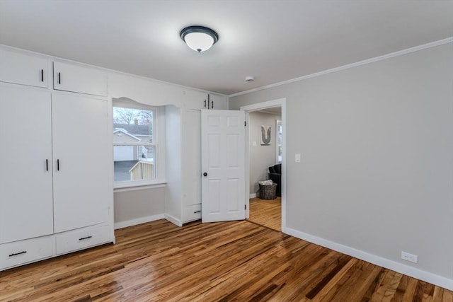 unfurnished bedroom featuring crown molding and light hardwood / wood-style flooring