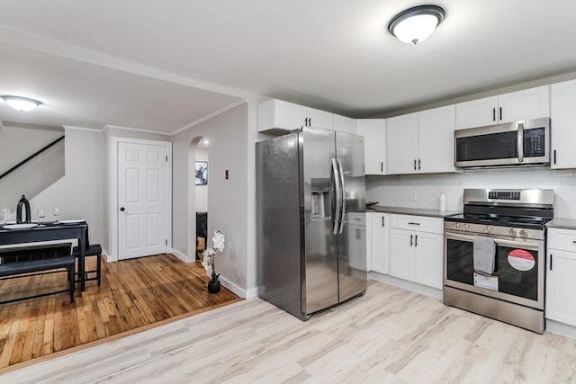 kitchen with white cabinetry, decorative backsplash, light wood-type flooring, and appliances with stainless steel finishes