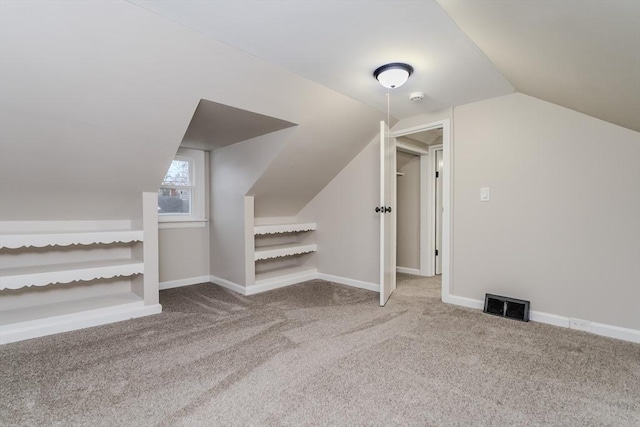 bonus room with lofted ceiling and carpet flooring