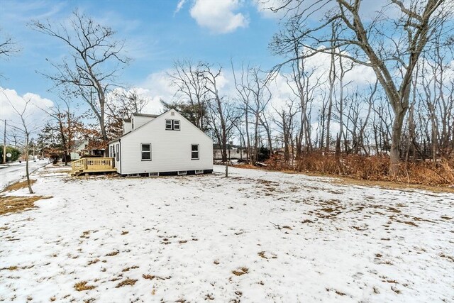 view of snow covered exterior featuring a wooden deck