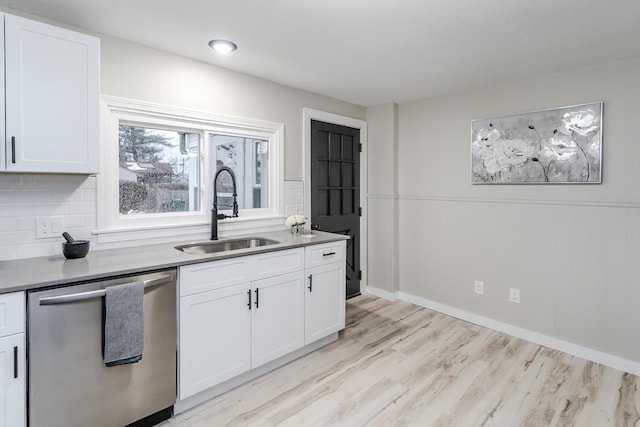 kitchen featuring dishwasher, sink, and white cabinets