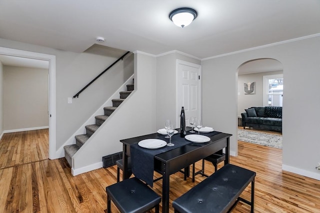 dining space with crown molding and wood-type flooring