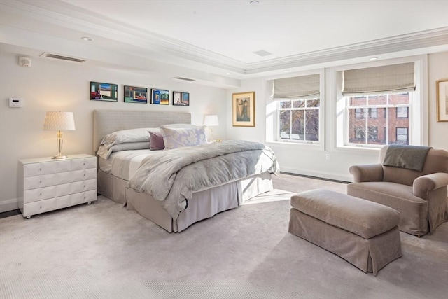 carpeted bedroom with a tray ceiling and crown molding