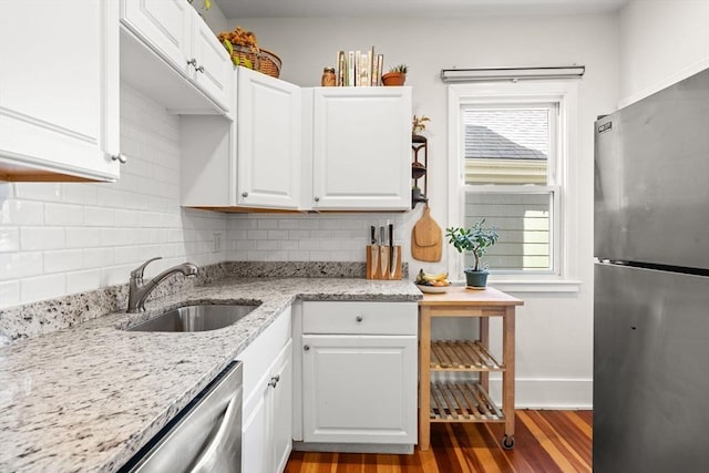 95 Child St Unit 2, Boston, MA 02130 - kitchen featuring stainless steel appliances, a sink, light wood-style floors, backsplash, and white cabinetry