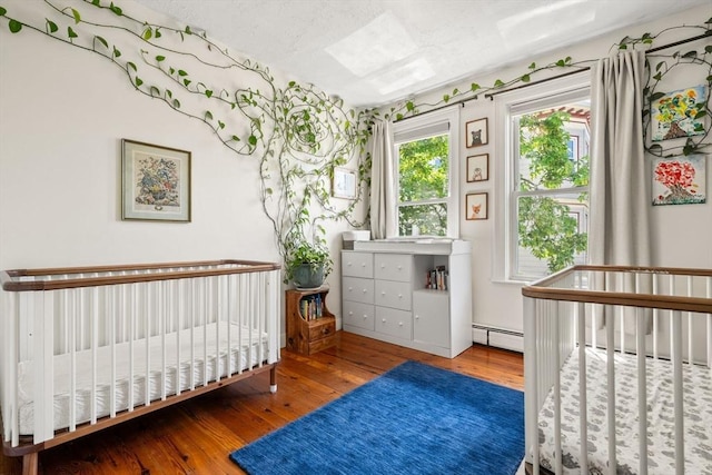 95 Child St Unit 2, Boston, MA 02130 - bedroom with wood-type flooring, baseboard heating, and a crib
