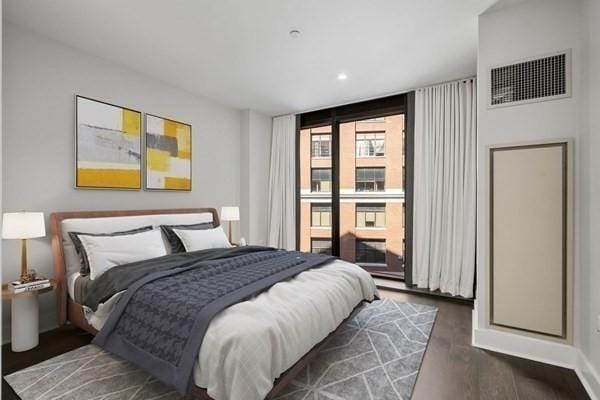 bedroom with dark hardwood / wood-style floors and floor to ceiling windows