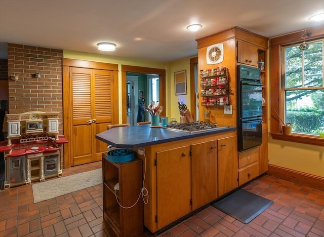 303 S St, Northampton, MA 01060 - kitchen with brick floors, dark countertops, a peninsula, and stainless steel gas cooktop