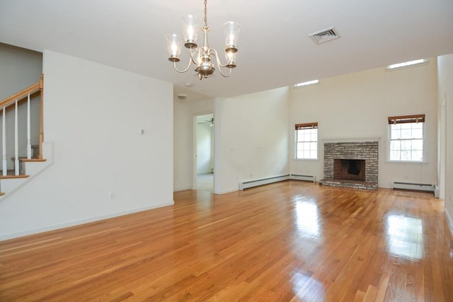 unfurnished living room featuring stairs, visible vents, baseboard heating, and an inviting chandelier