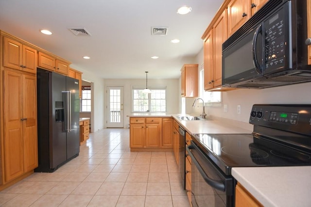 kitchen featuring a sink, black appliances, a peninsula, and visible vents