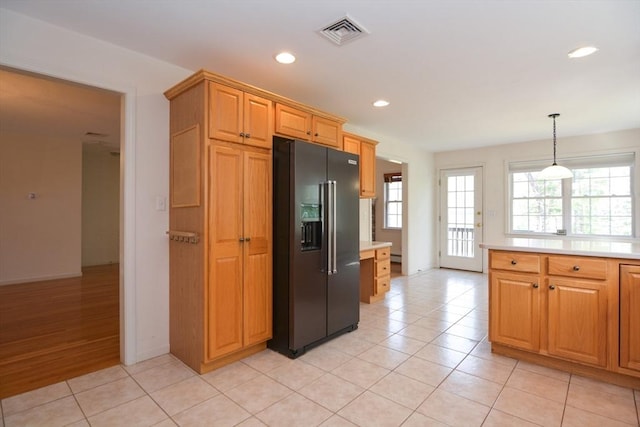 kitchen featuring light tile patterned flooring, light countertops, high end black fridge, recessed lighting, and visible vents