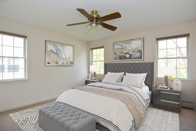 bedroom with carpet, baseboard heating, and multiple windows