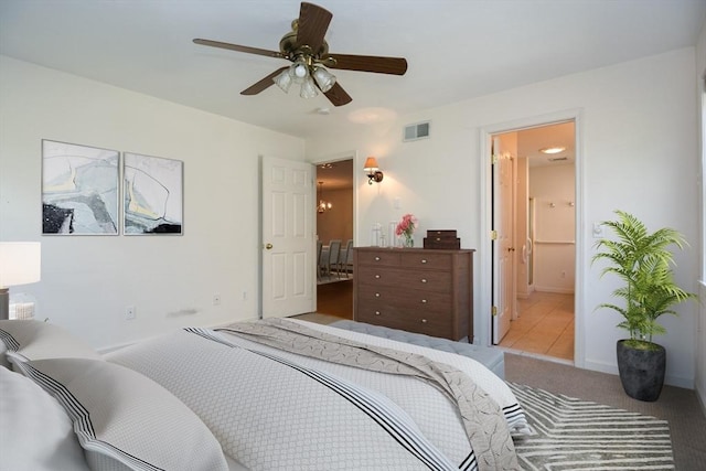 carpeted bedroom featuring a ceiling fan, connected bathroom, and visible vents