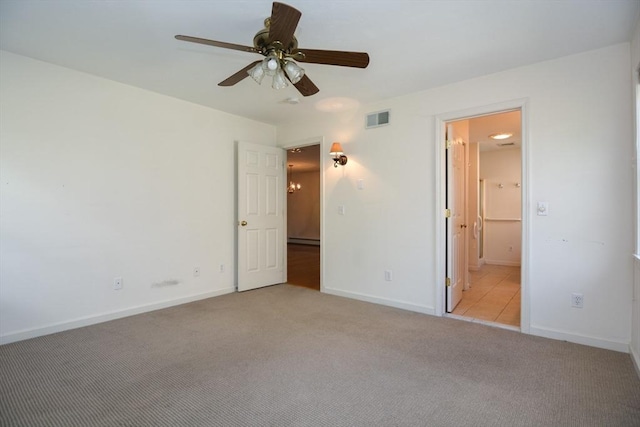 unfurnished bedroom with visible vents, baseboards, light colored carpet, a ceiling fan, and ensuite bath