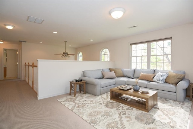 living area with visible vents, recessed lighting, ceiling fan, and light carpet
