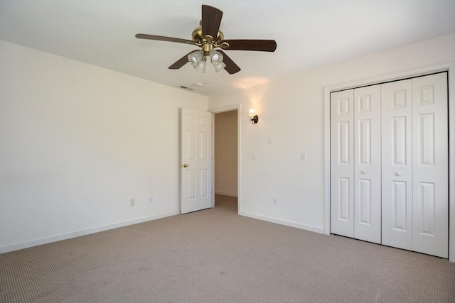 unfurnished bedroom featuring baseboards, a ceiling fan, a closet, and light carpet