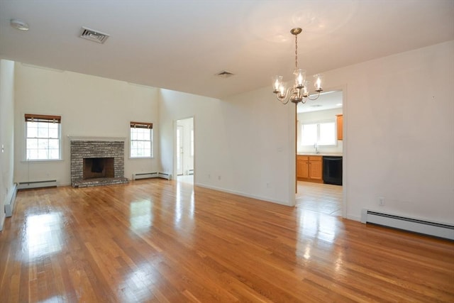 unfurnished living room featuring a notable chandelier, a healthy amount of sunlight, and visible vents