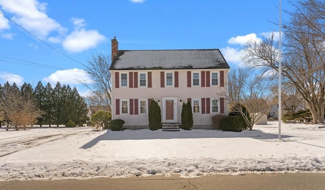 colonial-style house featuring a chimney