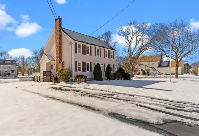 colonial-style house featuring a chimney