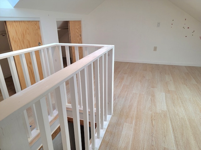 hallway featuring light hardwood / wood-style flooring and lofted ceiling