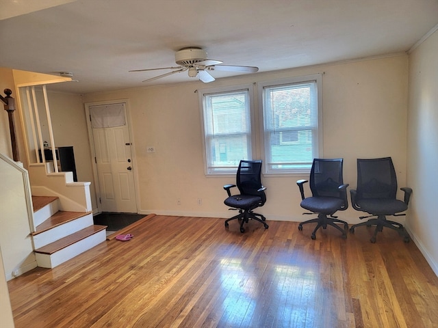 living area featuring hardwood / wood-style floors, ceiling fan, and crown molding