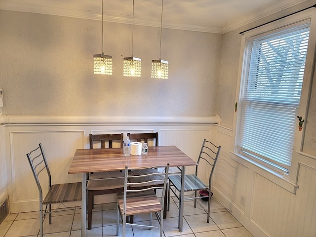 dining room featuring light tile patterned floors and crown molding