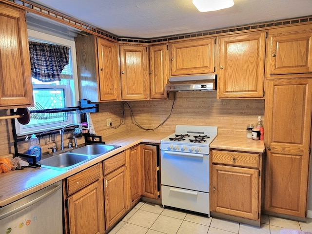 kitchen with dishwasher, white range oven, light tile patterned floors, and sink