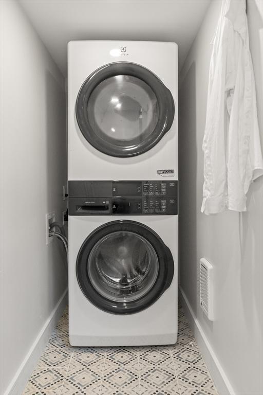 9 Upland Rd, Marblehead, MA 01945 - clothes washing area featuring estacked washer and dryer, baseboards, and tile patterned floors