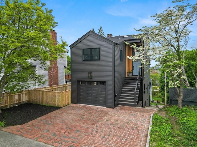 9 Upland Rd, Marblehead, MA 01945 - view of front of house featuring decorative driveway, an attached garage, fence, and stairway