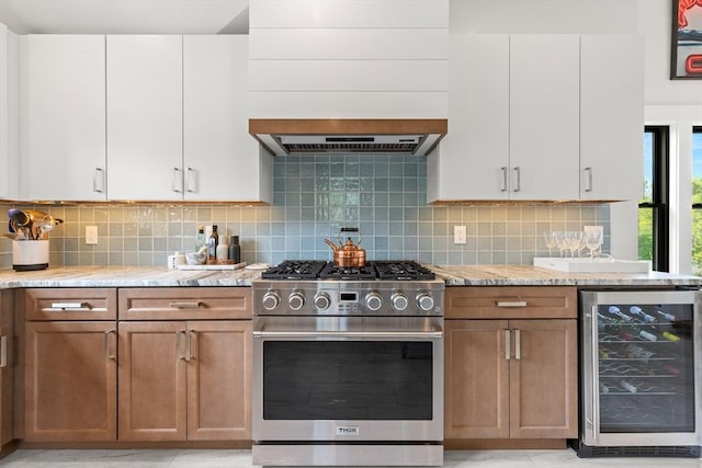 9 Upland Rd, Marblehead, MA 01945 - kitchen with high end stainless steel range, wine cooler, light stone counters, tasteful backsplash, and custom range hood