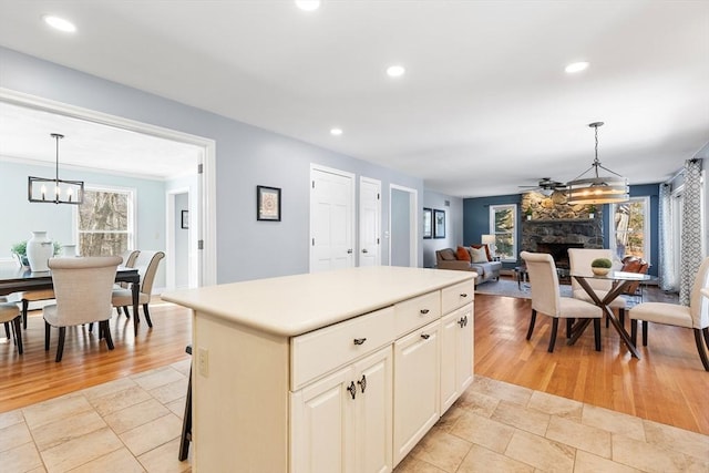 kitchen with a kitchen island, plenty of natural light, a fireplace, and decorative light fixtures