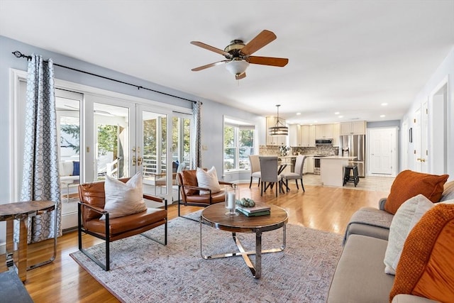 living room featuring french doors, ceiling fan, and light hardwood / wood-style floors