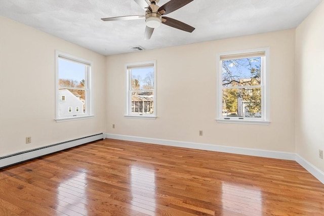 unfurnished room with a baseboard radiator, a healthy amount of sunlight, ceiling fan, and light hardwood / wood-style flooring