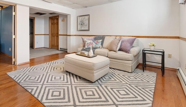 living room featuring a baseboard radiator, a drop ceiling, and light hardwood / wood-style flooring