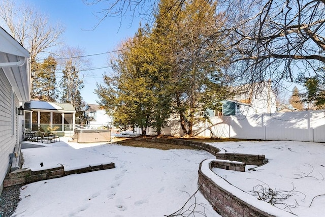 yard covered in snow with a hot tub and a sunroom