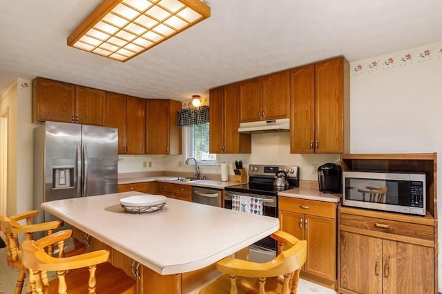 20 Starling Way, Leominster, MA 01453 - kitchen with stainless steel appliances, under cabinet range hood, a kitchen bar, and light countertops