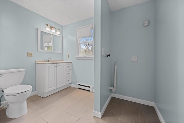 bathroom with a baseboard radiator, toilet, baseboards, vanity, and wood finished floors