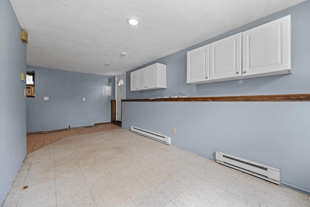 below grade area featuring a baseboard radiator, light floors, and a textured ceiling