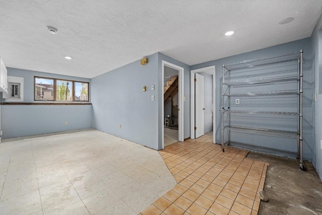 unfurnished living room with a textured ceiling and recessed lighting