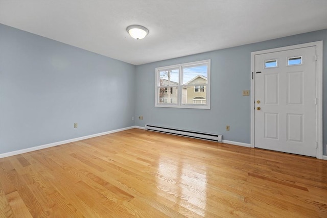 foyer entrance with baseboard heating, light wood-style flooring, and baseboards