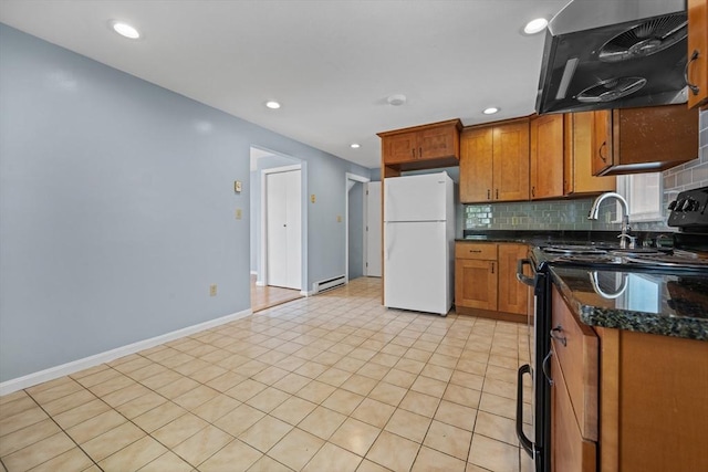 kitchen featuring freestanding refrigerator, ventilation hood, black electric range oven, baseboard heating, and tasteful backsplash