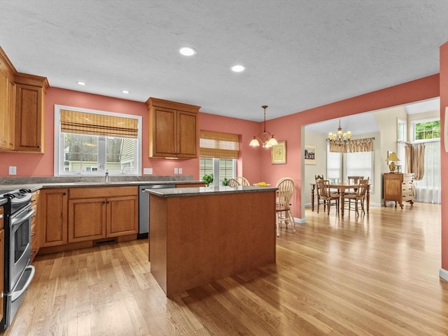 kitchen with stainless steel appliances, light wood-type flooring, a chandelier, brown cabinetry, and recessed lighting